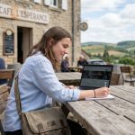 Jeune femme dans un café français avec guide sur ordinateur