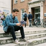 Jeune homme pensif en ville avec brochures de film