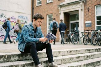 Jeune homme pensif en ville avec brochures de film