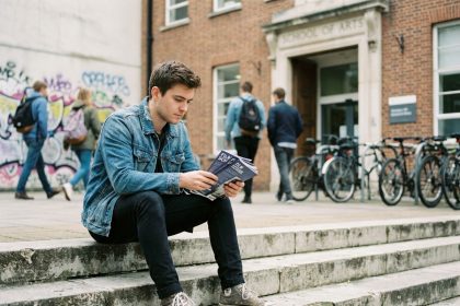 Jeune homme pensif en ville avec brochures de film